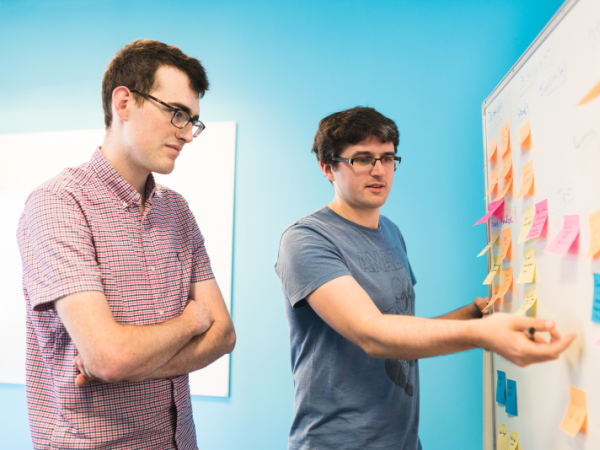 Trainer demonstrating software development on a whiteboard
